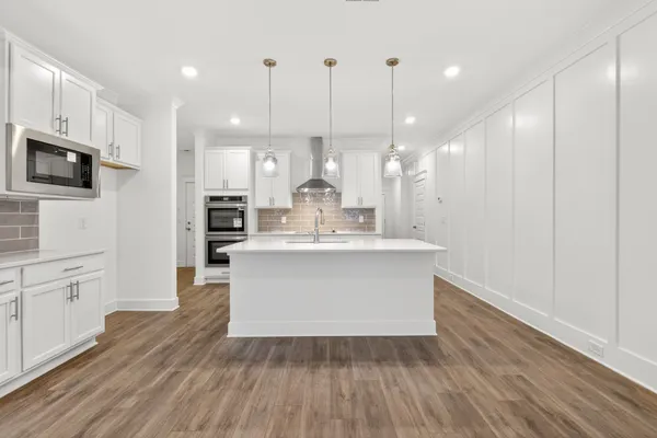a view of a kitchen with wooden floor and windows