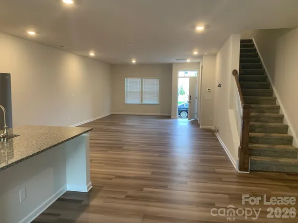 a view of hallway with stairs and wooden floor
