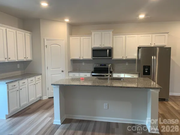a kitchen with stainless steel appliances a sink a stove a refrigerator and cabinets