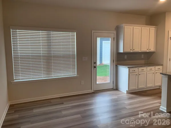 a view of a kitchen with wooden floor and a window