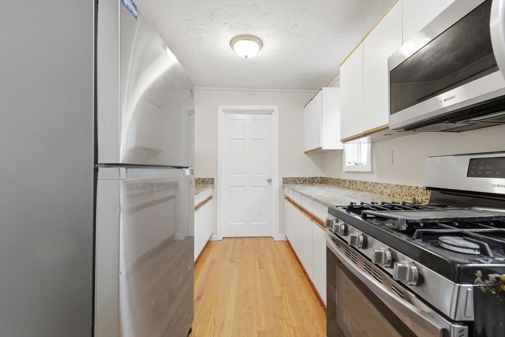 60 Tudor Street, Unit 1 Lynn, MA 01902 - Photo 1 of 19 a kitchen with a stove and a microwave