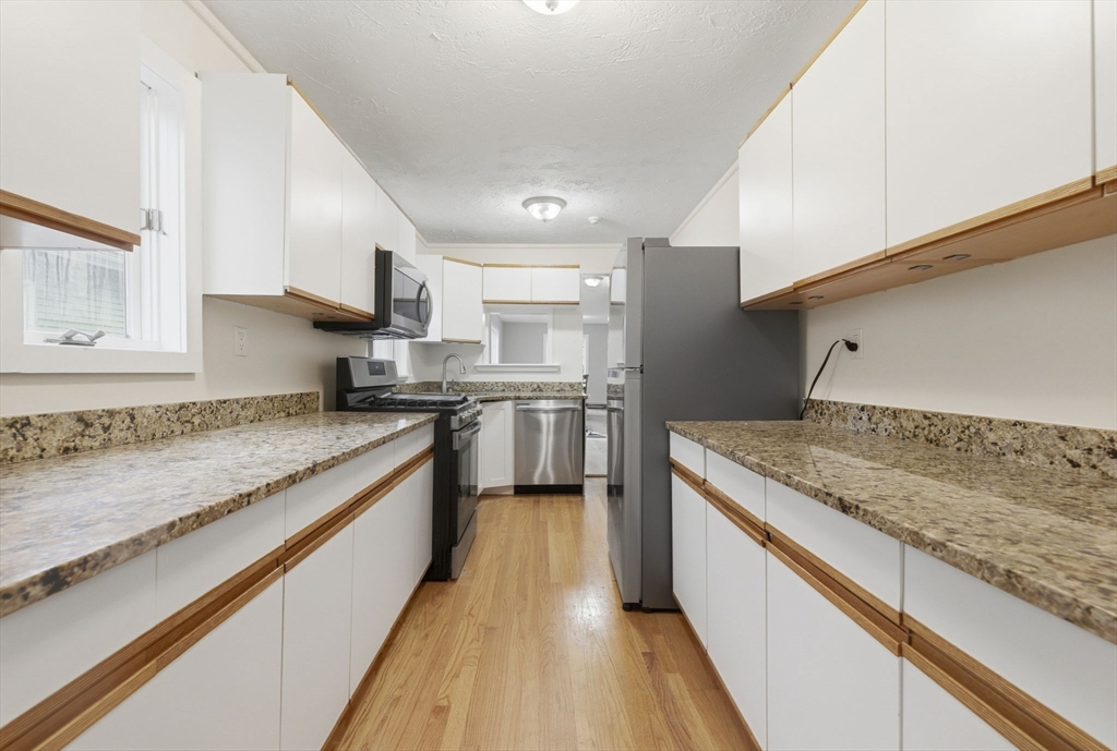 60 Tudor Street, Unit 1 Lynn, MA 01902 - Photo 4 of 19 a kitchen with stainless steel appliances granite countertop a sink and a stove