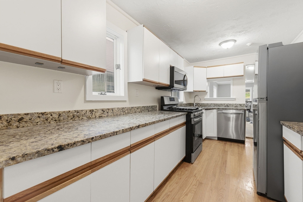 60 Tudor Street, Unit 1 Lynn, MA 01902 - Photo 5 of 19 a kitchen with stainless steel appliances granite countertop a sink a stove and a refrigerator