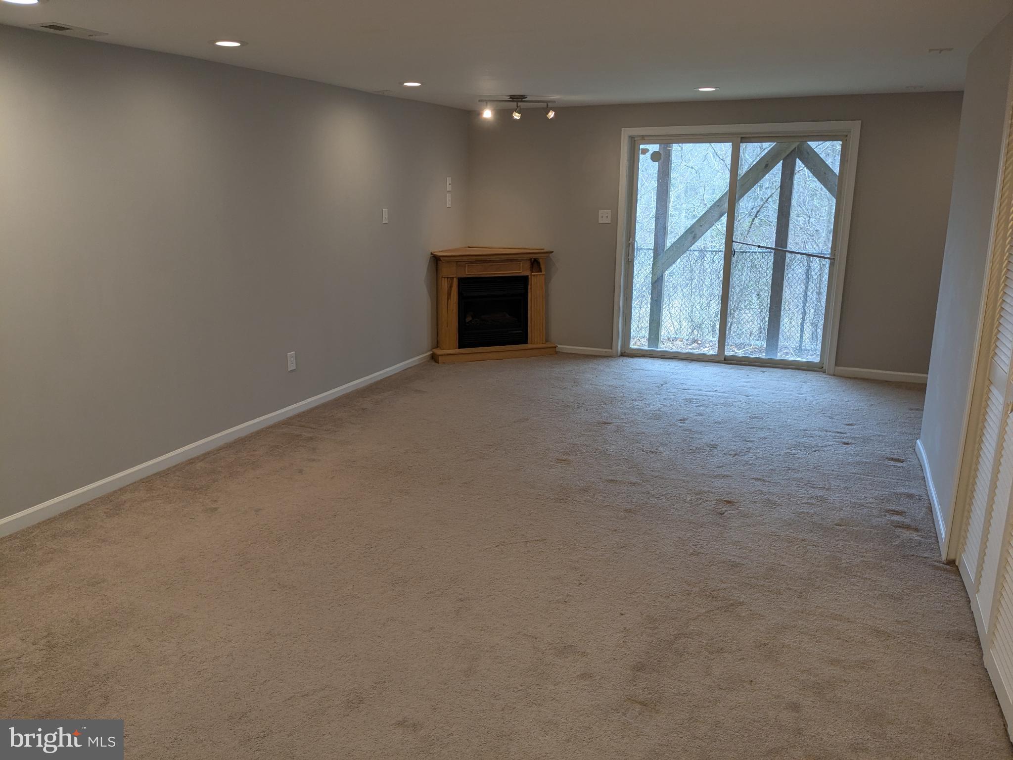 25 Millstream Road Pine Hill, NJ 08021 - Photo 13 of 28 an empty room with a fireplace and large window
