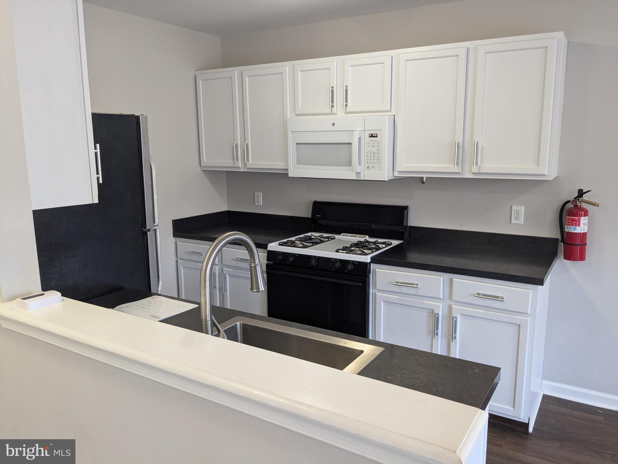 25 Millstream Road Pine Hill, NJ 08021 - Photo 6 of 28 a kitchen with granite countertop white cabinets and black appliances