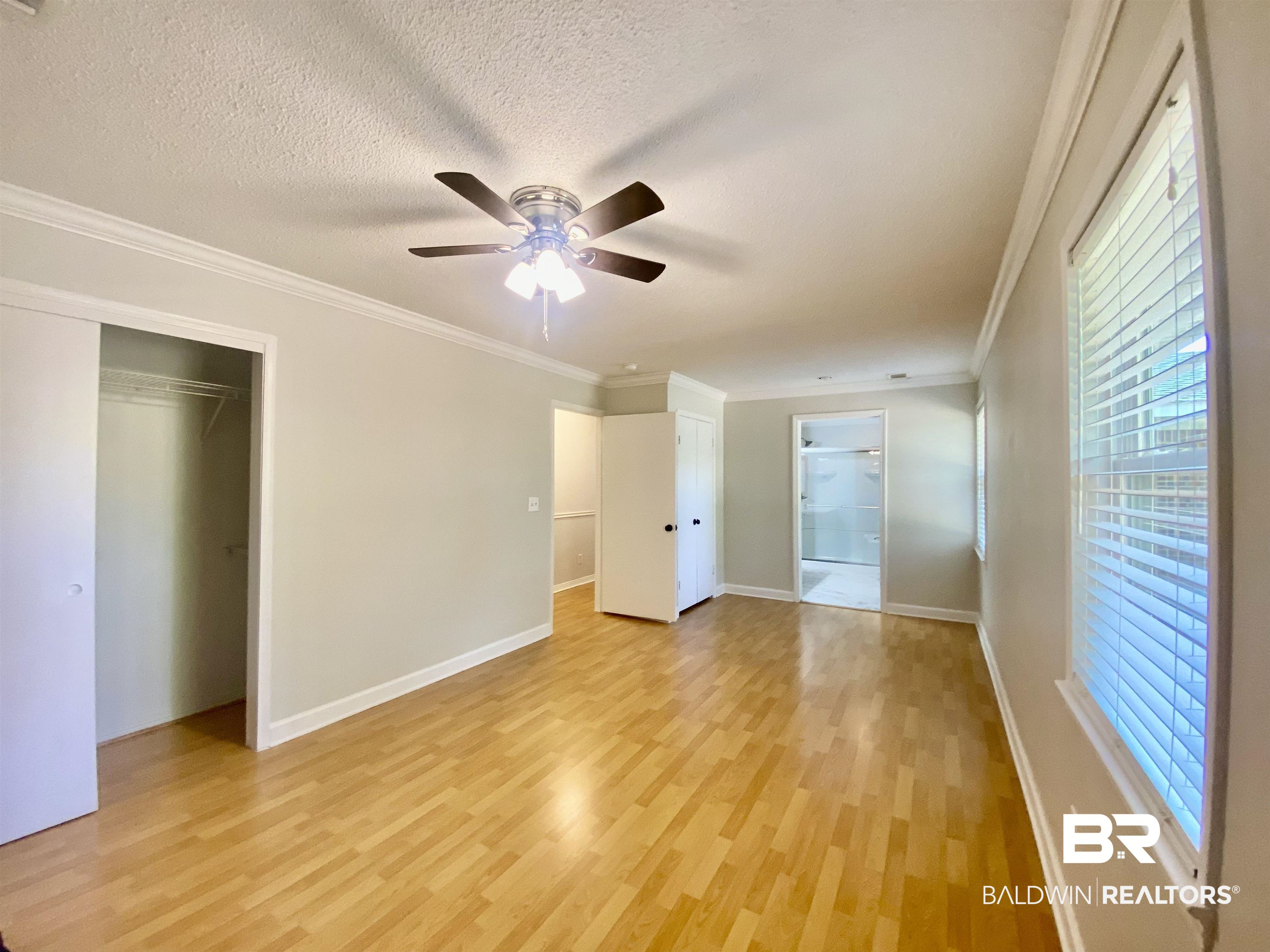 265 Azalea Drive Monroeville, AL 36460 - Photo 26 of 39 Unfurnished bedroom featuring a textured ceiling, light wood-type flooring, ceiling fan, and crown molding