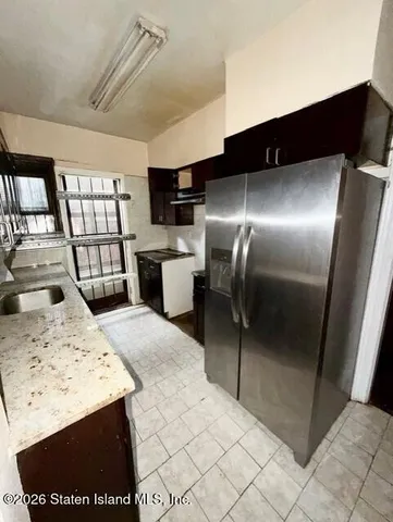 a kitchen with granite countertop a sink a stove and cabinets