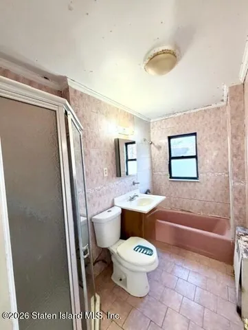 an empty room with wooden floor chandelier fan and windows