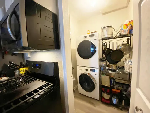 a utility room with dryer washer and a view of living room