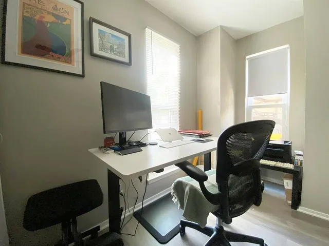 a view of a workspace with furniture and wooden floor