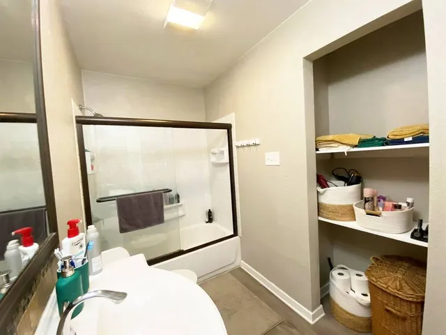 a view of a hallway with closet and wooden floor
