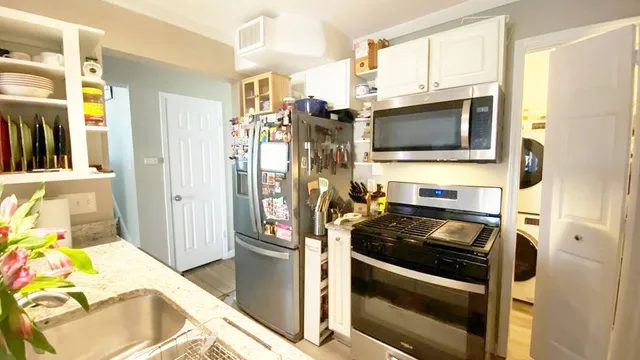 a kitchen with stainless steel appliances a stove a microwave and a refrigerator