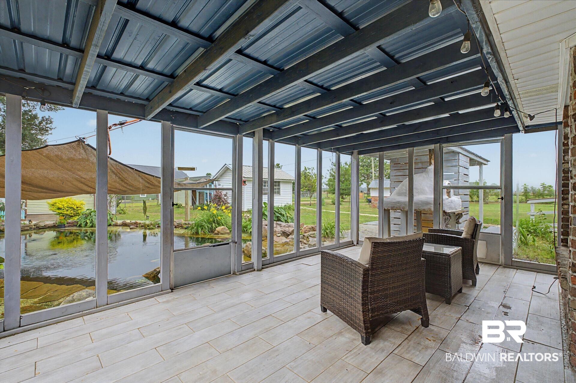 3791 Robinsonville Road Atmore, AL 36502 - Photo 2 of 47 Screened porch featuring light wood-finish flooring and a corrugated metal ceiling
