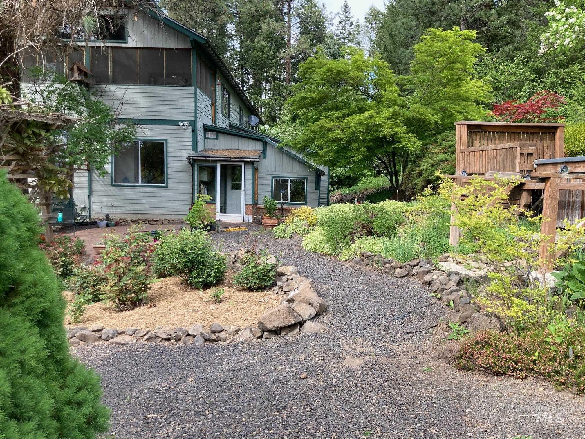 266 Falcon Ridge Road Kooskia, ID 83539 - Photo 4 of 50 Multi-level exterior with light green siding and dark trim. Back door opens from sun room into backyard patio and fenced in garden area