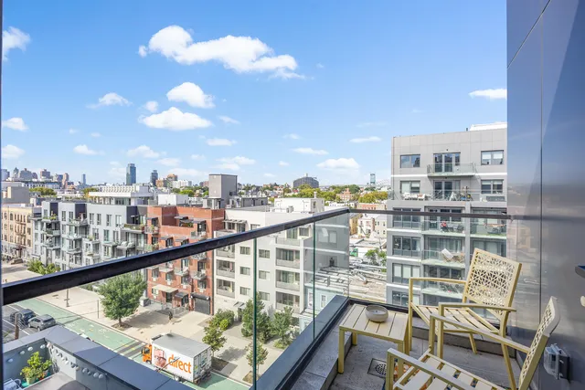 a kitchen with kitchen island granite countertop a refrigerator a stove and a sink with wooden floor