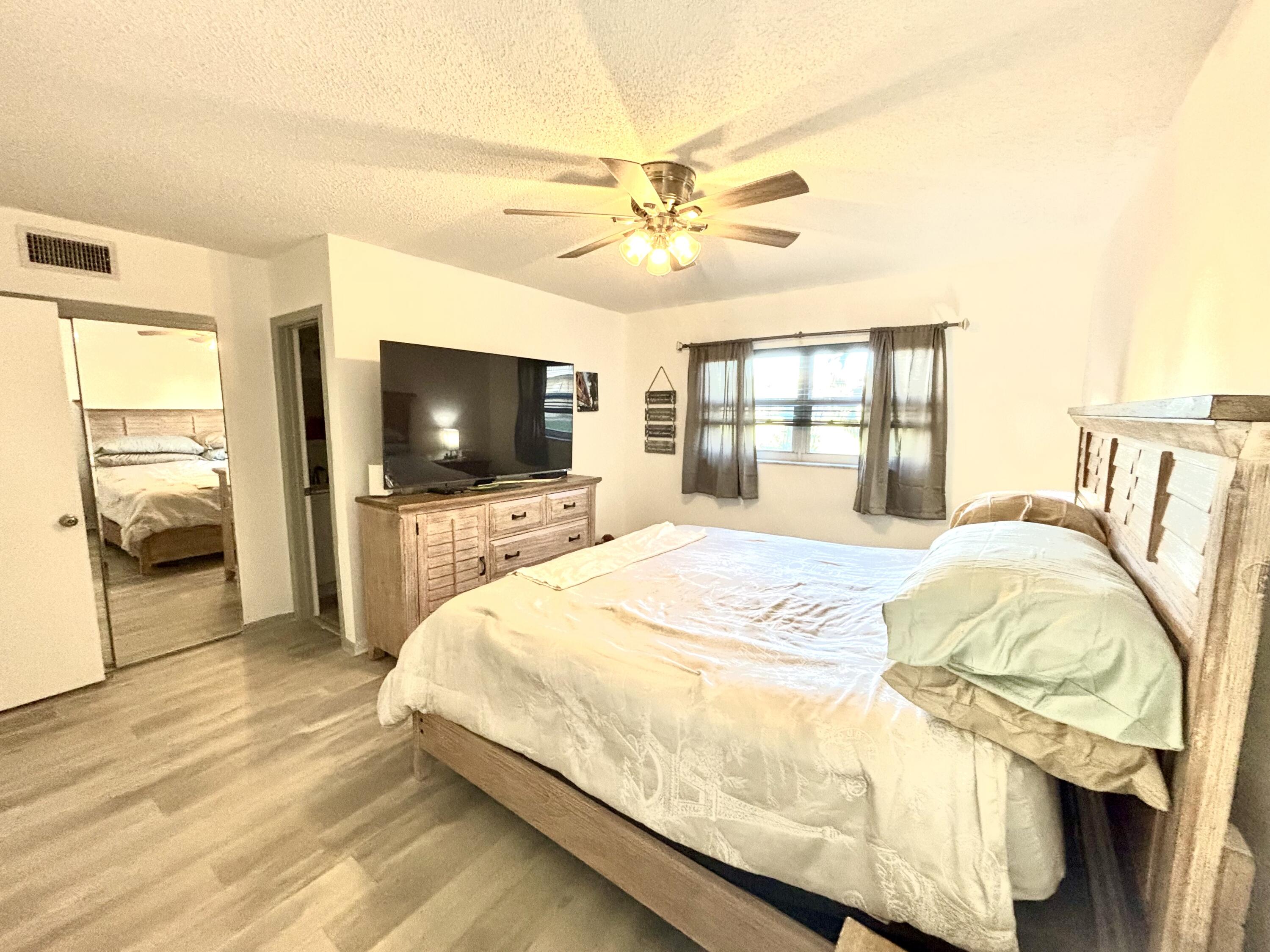 2600 Northeast 1st Lane, Unit 104 Boynton Beach, FL 33435 - Photo 23 of 41 a bedroom with a bed and a flat screen tv