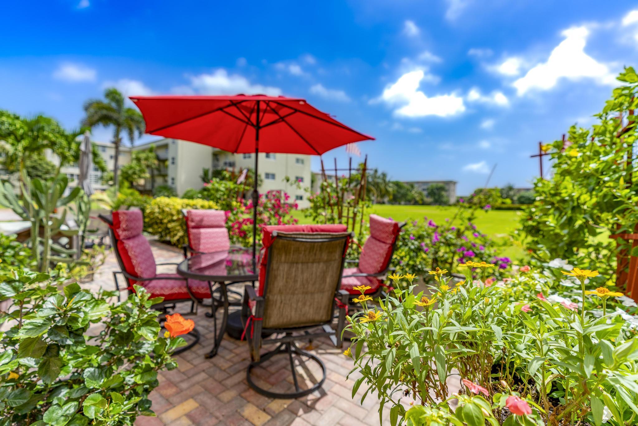 2600 Northeast 1st Lane, Unit 104 Boynton Beach, FL 33435 - Photo 28 of 41 a view of a chairs and table in the patio