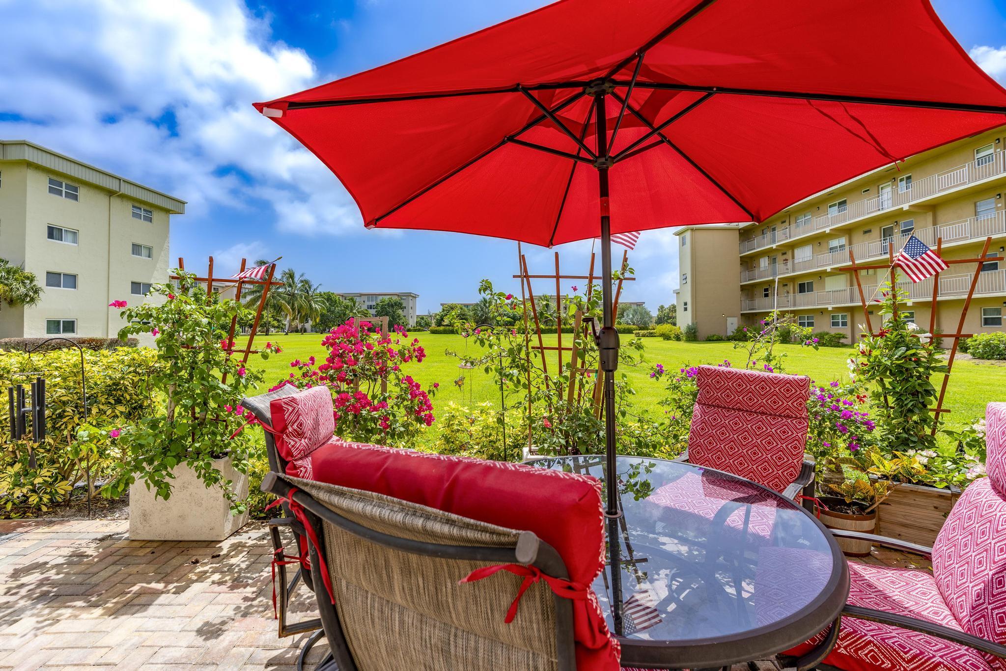2600 Northeast 1st Lane, Unit 104 Boynton Beach, FL 33435 - Photo 30 of 41 a view of an outdoor sitting area with furniture and umbrella