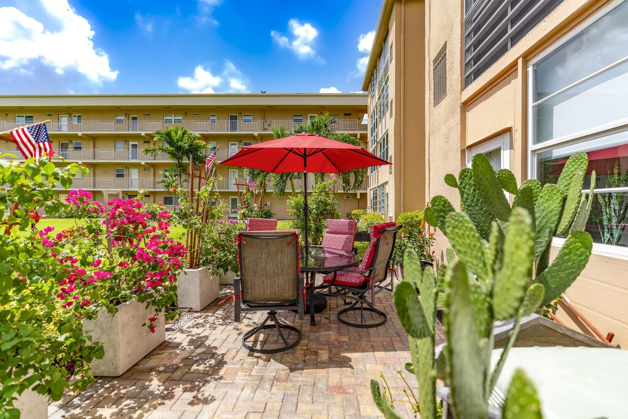 2600 Northeast 1st Lane, Unit 104 Boynton Beach, FL 33435 - Photo 31 of 41 a view of a chairs and table in patio with a fire pit