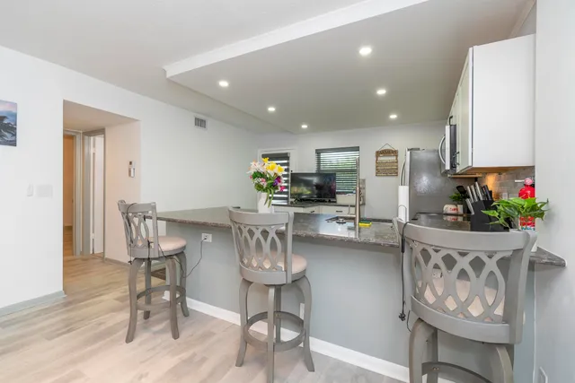 a kitchen with stainless steel appliances kitchen island granite countertop furniture and a dining table