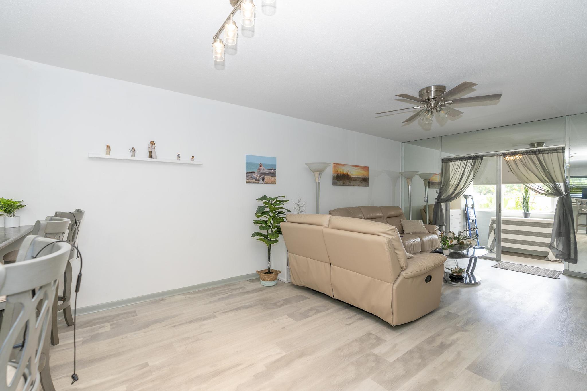 2600 Northeast 1st Lane, Unit 104 Boynton Beach, FL 33435 - Photo 9 of 41 a living room with furniture and a chandelier