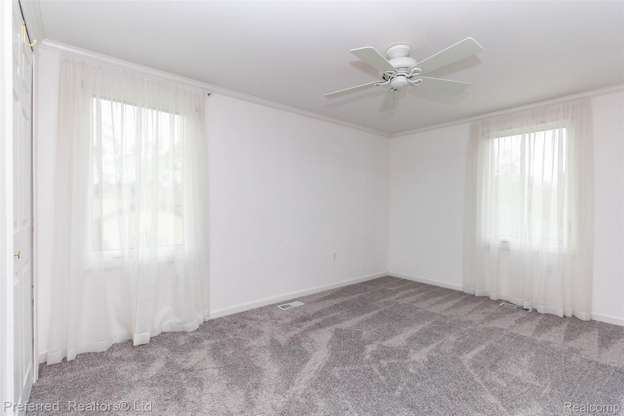 9840 Currie Road Northville, MI 48167 - Photo 21 of 62 Spare room with ornamental molding, ceiling fan, and carpet flooring