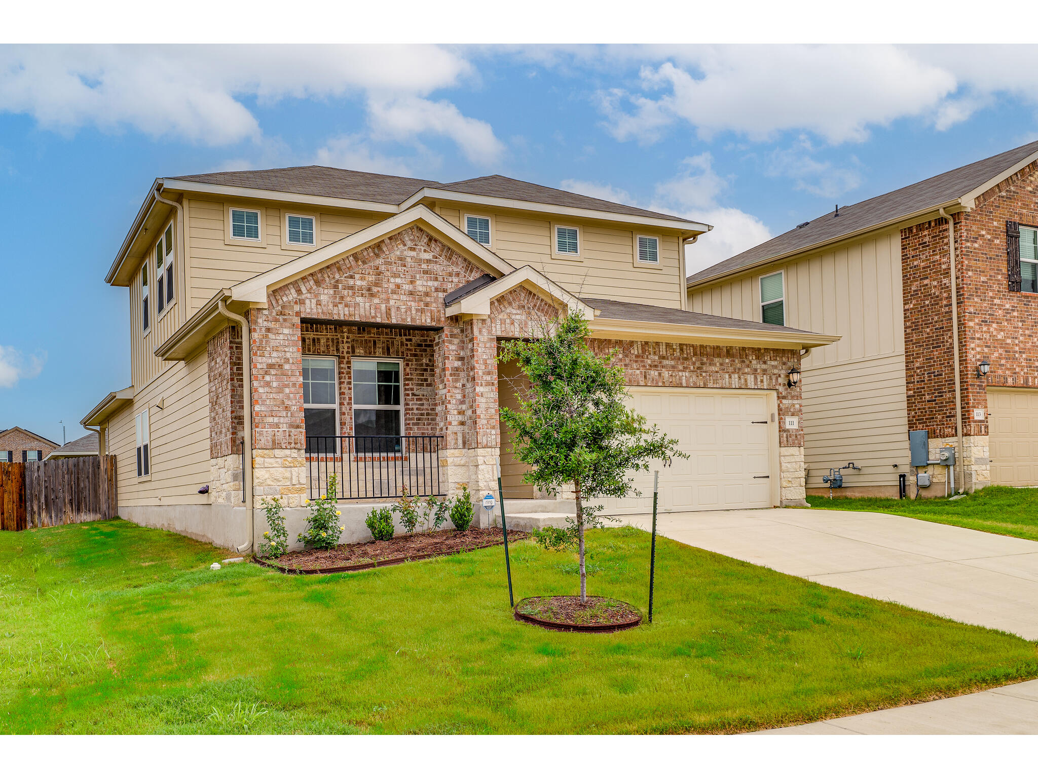 View of front of property with a garage, driveway, and brick siding