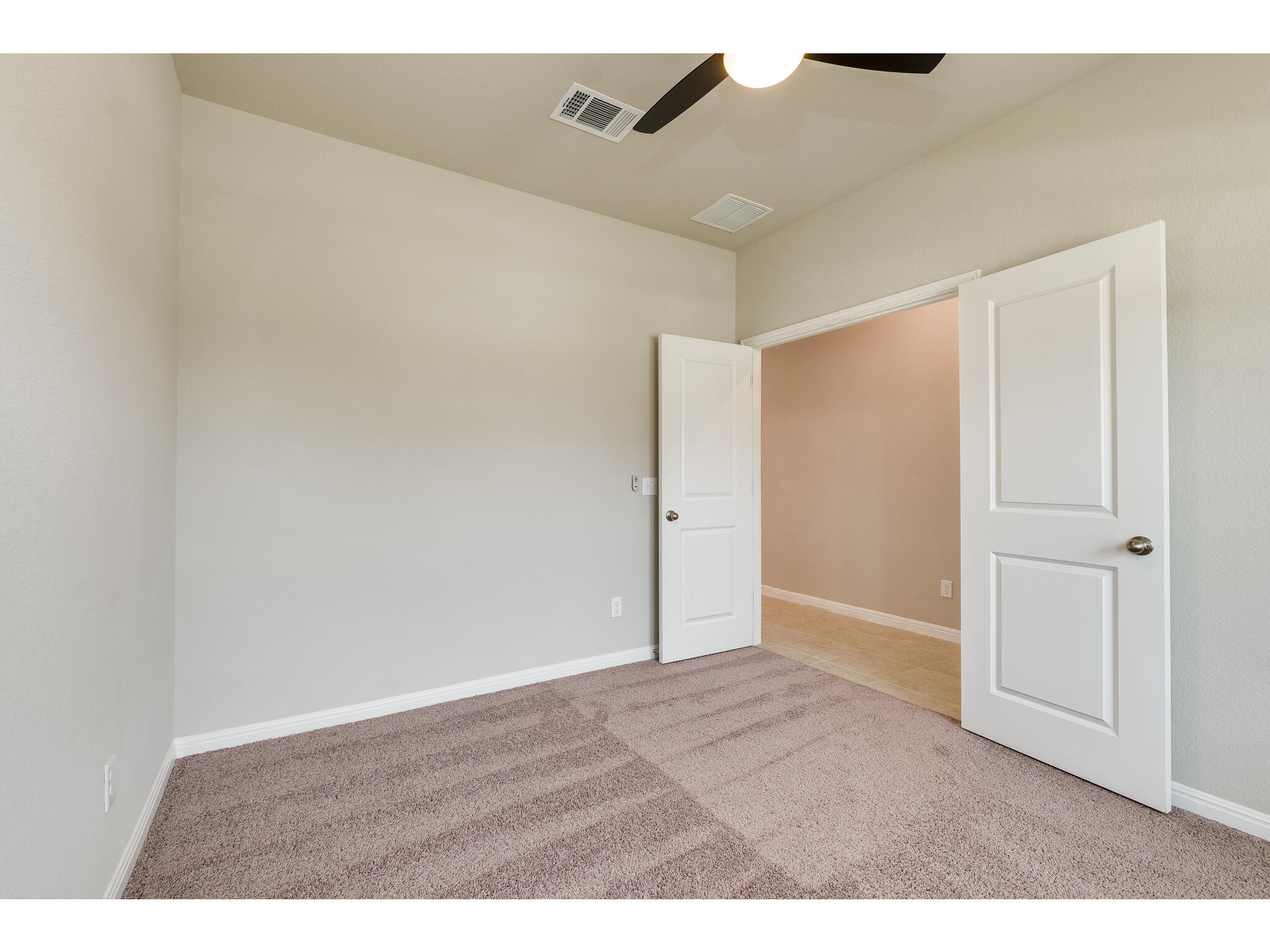111 Grapefruit Road Hutto, TX 78634 - Photo 10 of 39 Unfurnished bedroom with carpet floors, baseboards, and a ceiling fan