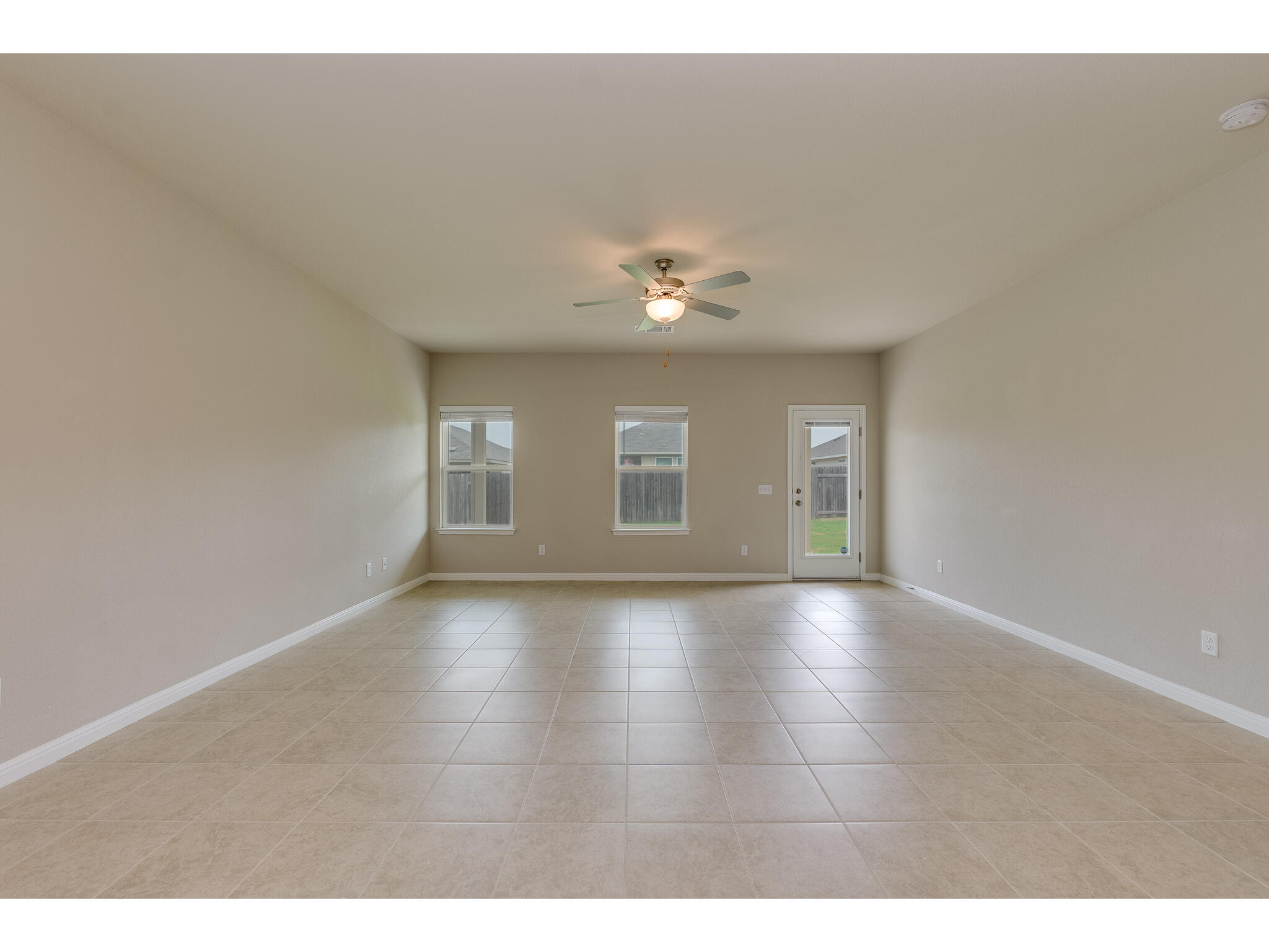 111 Grapefruit Road Hutto, TX 78634 - Photo 16 of 39 Empty room featuring a ceiling fan, light tile patterned floors, and baseboards