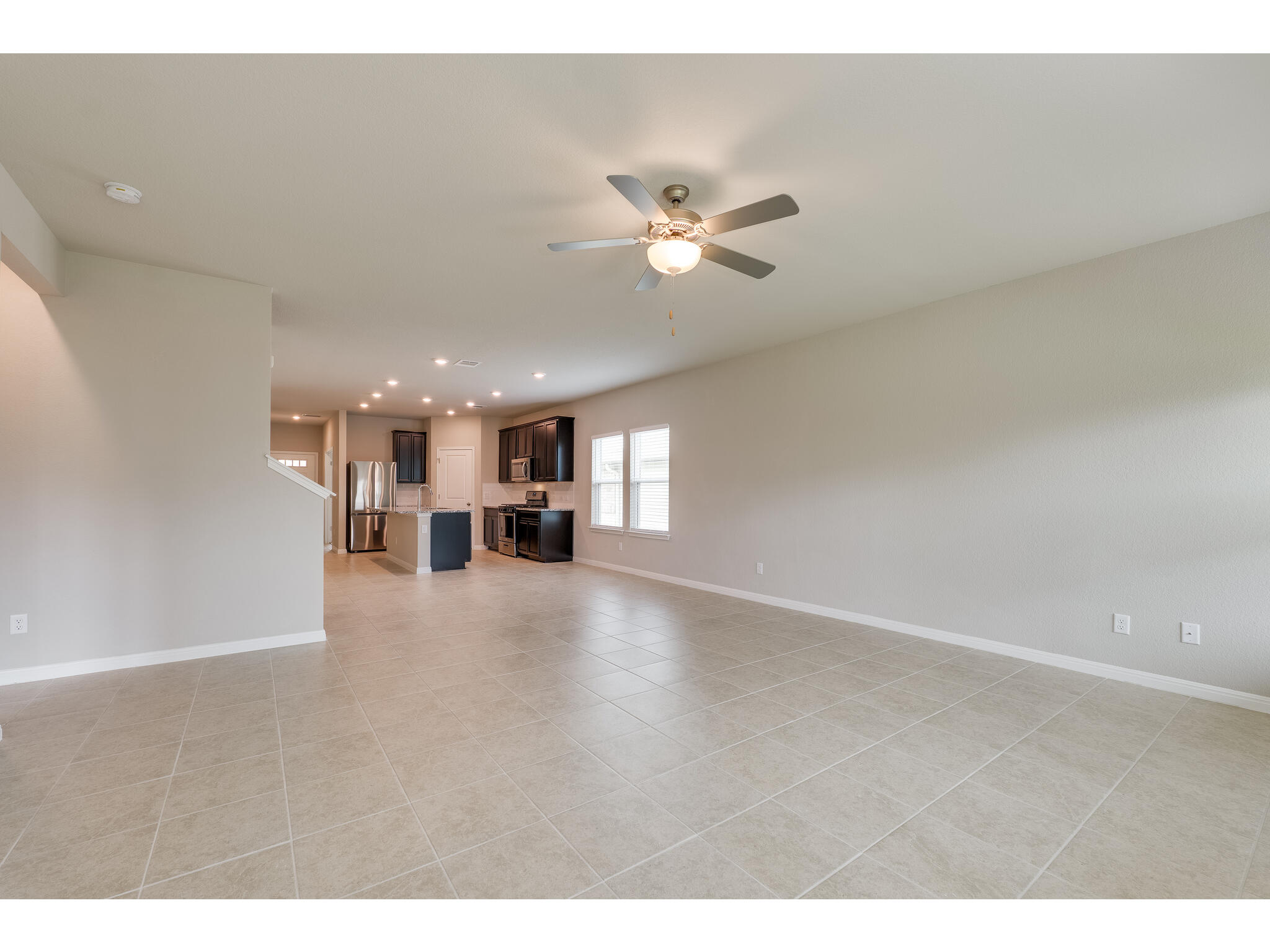111 Grapefruit Road Hutto, TX 78634 - Photo 17 of 39 Unfurnished living room featuring ceiling fan, light tile patterned flooring, baseboards, and recessed lighting