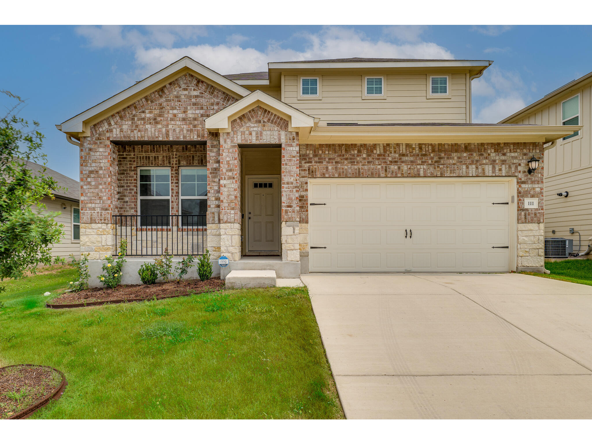 111 Grapefruit Road Hutto, TX 78634 - Photo 2 of 39 View of front of property with driveway, a front yard, brick siding, and stone siding