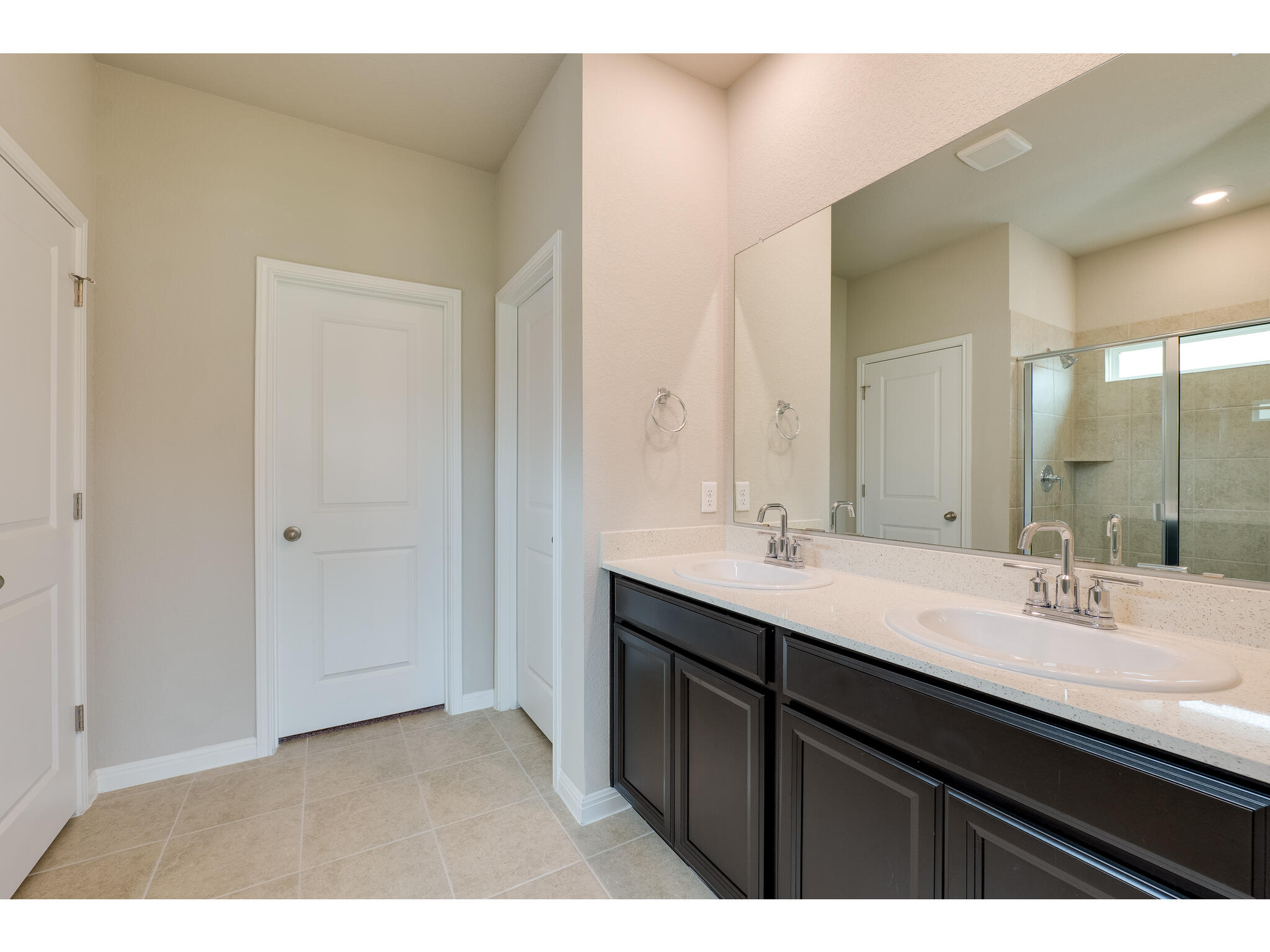 111 Grapefruit Road Hutto, TX 78634 - Photo 20 of 39 Bathroom featuring double vanity, a stall shower, baseboards, and tile patterned floors