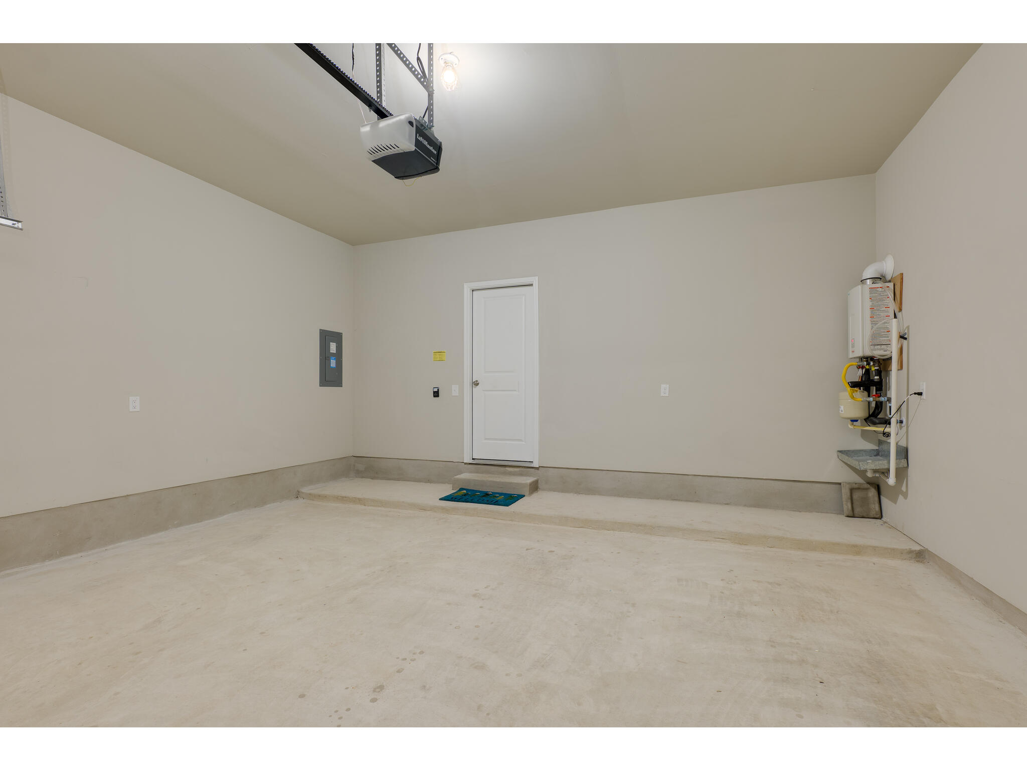 111 Grapefruit Road Hutto, TX 78634 - Photo 33 of 39 Garage with a garage door opener, electric panel, and water heater