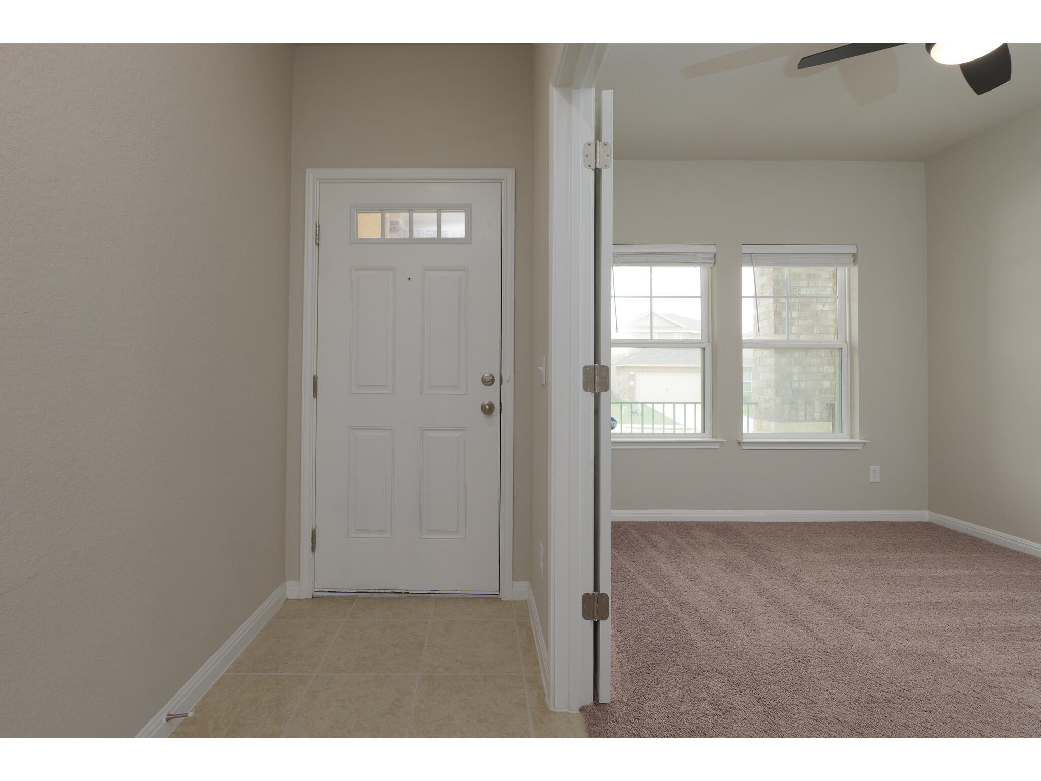 111 Grapefruit Road Hutto, TX 78634 - Photo 6 of 39 Foyer entrance with ceiling fan, baseboards, and light carpet