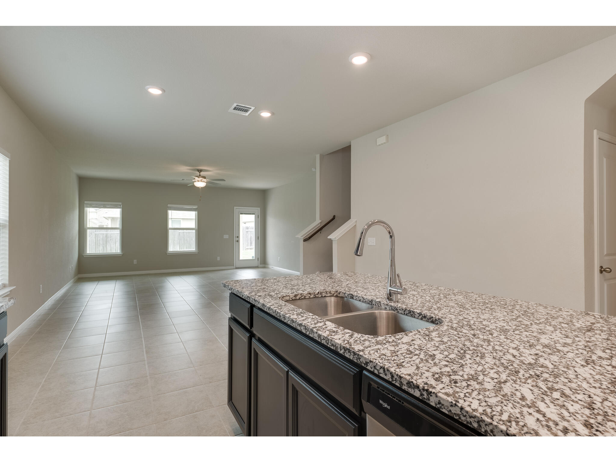 111 Grapefruit Road Hutto, TX 78634 - Photo 8 of 39 Kitchen with a sink, a ceiling fan, light tile patterned floors, light stone counters, and recessed lighting