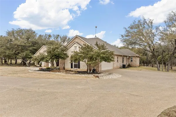 a front view of house with yard and trees around