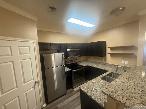 a kitchen with stainless steel appliances granite countertop a refrigerator and a sink