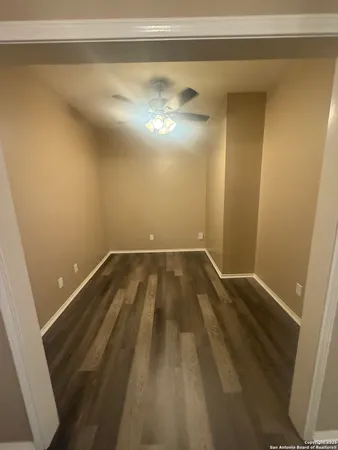 a view of a room with wooden floor and cabinets