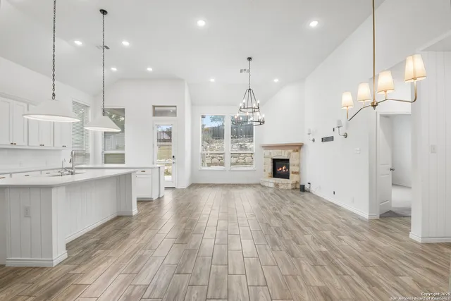 a large kitchen with a lot of cabinets and wooden floor