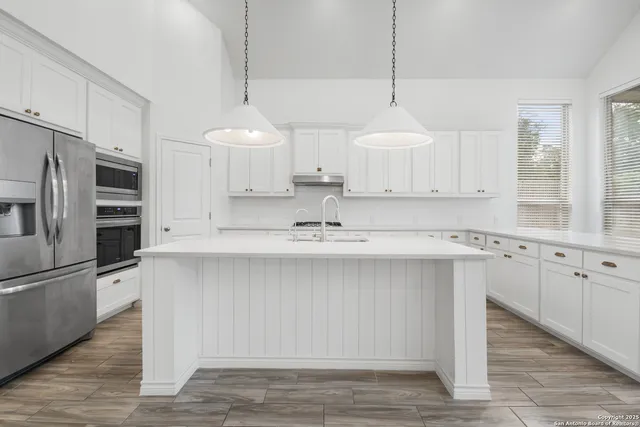 a kitchen with stainless steel appliances a sink stove and refrigerator