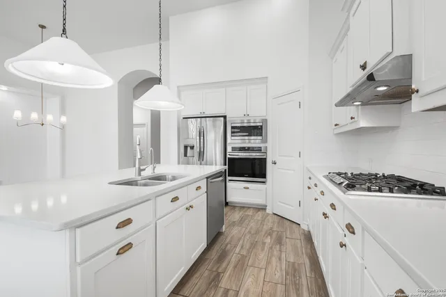 a kitchen with stainless steel appliances a sink stove and cabinets