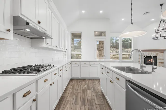 a kitchen with granite countertop a sink stove and cabinets