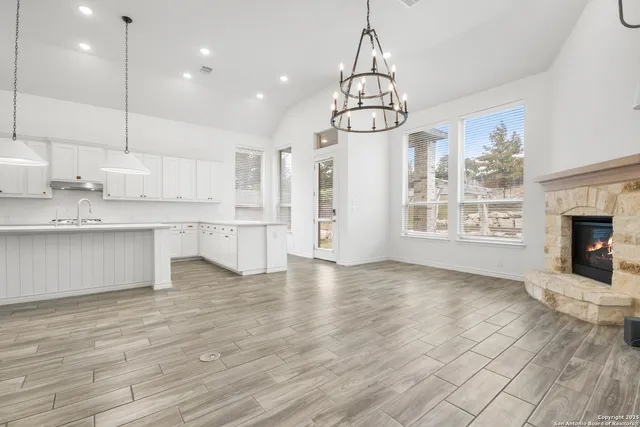 a view of a kitchen with a sink dishwasher and fireplace