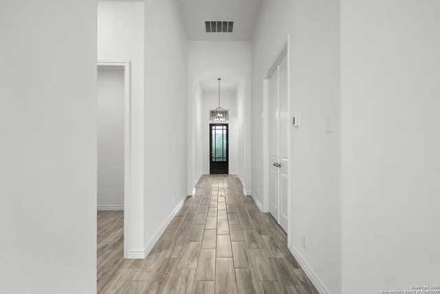 a view of a hallway with wooden floor and staircase