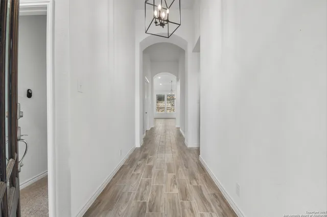 a view of a hallway with wooden floor and a door