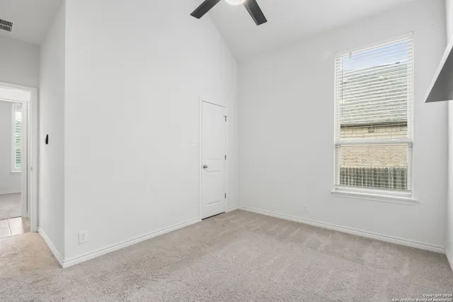 an empty room with a window and a fan