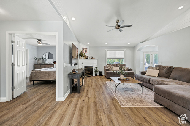 2280 South 450 West Perry, UT 84302 - Photo 5 of 38 Living room featuring a glass covered fireplace, light wood-style floors, recessed lighting, arched walkways, and french doors