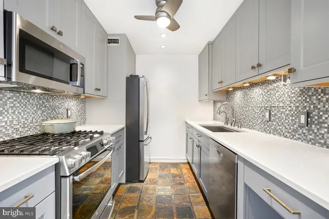 a kitchen with stainless steel appliances a stove microwave and refrigerator