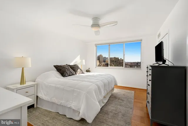 a bedroom with a bed and a flat tv screen on dresser
