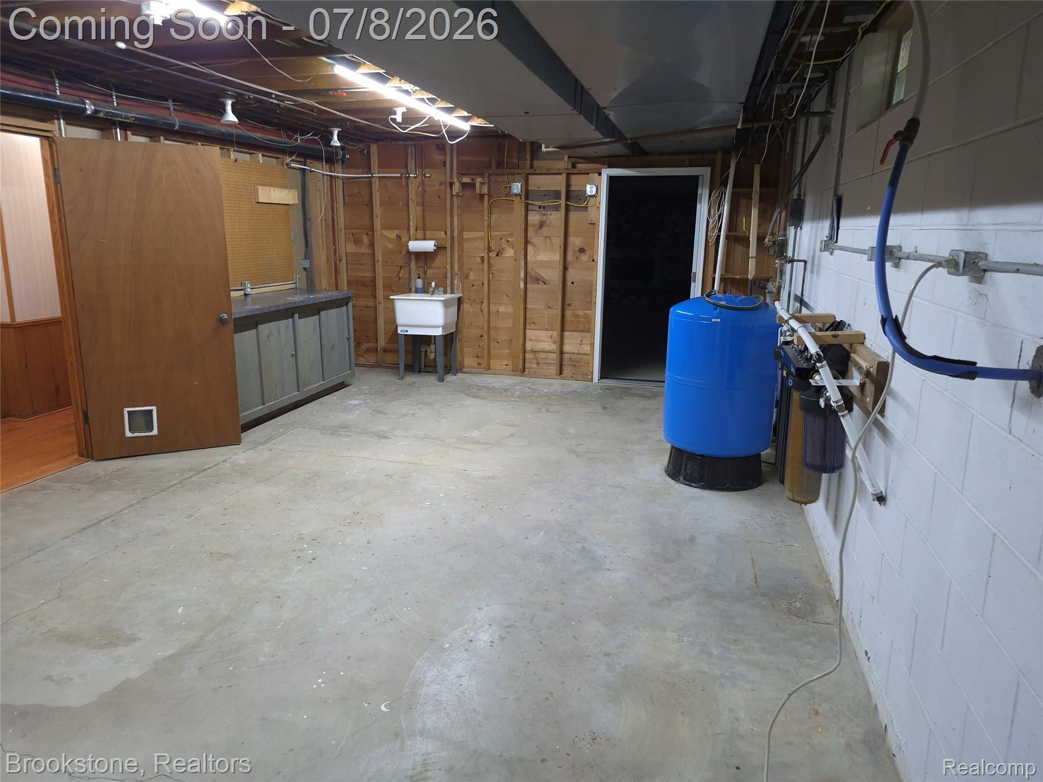 4140 South Henderson Road Davison, MI 48423 - Photo 79 of 98 Spacious utility room featuring a concrete floor, exposed wood framing, a utility sink, and visible plumbing